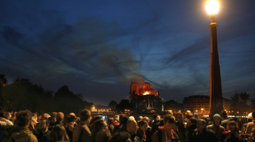Parīzes iedzīvotāji vēro ugunsgrēku Parīzes Dievmātes katedrālē. Foto: EPA/IAN LANGSDON