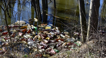 Applūdusi pļava starp Vienības gatvi un Torņakalna staciju un peldošas platsmasas pudeles. Foto: Īriss Sviklis, LETA