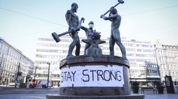 Uzraksts uz pazīstamās Helsinku trīs kalēju statujas vēsta: "Esi stiprs!" Statuja Covid-19 pandēmijas laikā ieguvusi arī koronavīrusam atbilstošu "ekipējumu". Foto: EPA/Scanpix/LETA/KIMMO BRANDT