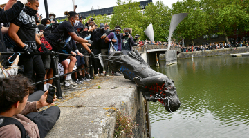 Protestētāji Anglijas pilsētā Bristolē sestdien nogāza un ostas ūdeņos iemeta bijušā vergu tirgotāja Edvarda Kolstona (1636—1721) statuju.
Foto — AFP/LETA