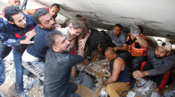 Glābēji pēc Izraēlas apšaudes 16. maijā izglābj no sagrautas ēkas drupām kādu meitenīti Gazas joslā.
Foto — Scanpix