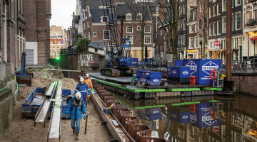 Kanālmalas mūra nostiprināšana ar tērauda lokšņu pāļiem vienā no vecākajiem Amsterdamas rajoniem Groenburgwal.
Foto — The New York Times