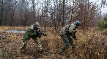 Viesmīle Anastasija Bilošitska brīvprātīgo militārajās mācībās netālu no Kijevas decembra sākumā.
Foto — The New York Times