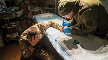 Militārais mediķis operē viegli ievainotu ukraiņu karavīru 17. janvārī Doneckas frontē.
Foto — Scanpix