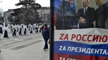 Krievijas preizticīgo baznīcas gājiens Krimā šogad janvārī Sevastopolē. Plakātā redzams Krievijas prezidents Putins, kurš spiež roku Maskavas ieceltajiem Krievijas okupēto reģionu vadītājiem Ukrainas austrumos. Foto - AP/Scanpix/LETA