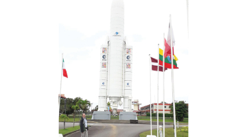 Roberts Purvinskis pie nesējraķetes Ariane 5 modeļa Kuru kosmodromā. Tur plīvo arī sarkanbaltsarkanais karogs, jo Latvija ir Eiropas Kosmosa aģentūras asociētā dalībvalsts.
Foto no personīgā arhīva