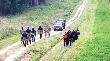 Baltkrievu robežsargi pavada migrantus uz Lietuvas robežu.
Foto — Lietuvas robežsardze