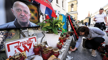 Jevgeņija Prigožina atbalstītāji noliek ziedus pie stihiski ierīkota piemiņas memoriāla Maskavas centrā.
Foto — Scanpix