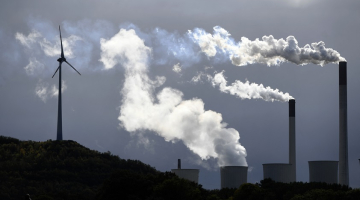 Dūmi no globālās energoapgādes uzņēmuma "Uniper" ogļu spēkstacijas līdzās vēja turbīnai Vācijas pilsētā Gelzenkirhenē 2019. gadā. Foto - INA FASSBENDER, AFP