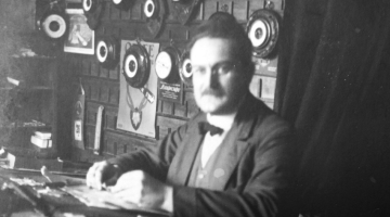 Eduards Gailis savā veikalā Brīvības ielā 20. gadsimta 20.—30. gados. Veikala ārskata fotogrāfijas nav saglabājušās, un šī ir vienīgā, kurā redzams iekšskats. Tirgoti arī barometri un termometri.
Foto no Gaiļu dzimtas arhīva