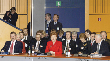 Latvijas prezidentes Vairas Vīķes-Freibergas ietekmīgā runa NATO samitā Prāgā 2002. gada 21. novembrī. Pa kreisi — Igaunijas premjerministrs Sīms Kallass, pa labi — Lietuvas prezidents Valds Adamkus.
Foto — Image Forum