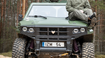 Ideja par militārās mašīnas radīšanu Ali Jansonam (pa labi) dzima, kad vēl nebija ne inženieru, ne atbilstoši iekārtotas darbnīcas. Tagad tas viss ir, un ir arī uzticams biznesa partneris — Mārtiņš Dzenītis. Numurzīmē burti «IZM» apzīmē izmēģinājuma auto.
Foto — Ieva Salmane