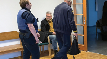Lato Lapsa un Mihails Uļmans (ar muguru) Mārtiņa Bunkus slepkavības tiesas sēdes pārtraukumā pagājušā gada februārī,