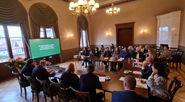 2025. gada 28. oktobra 14. Saeimas Valsts pārvaldes un pašvaldības komisijas sēde Kuldīgas jaunajā rātsnamā, aiz loga vecais rātsnams un vecākā Kurzemes koka ēka. Kristīnes Jarinovskas foto.