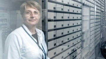 Rīgas Austrumu slimnīcas Aptiekas dienesta vadītāja Laila Eglīte rāda automatizētu zāļu skapi, kas ievestos medikamentus šķiro un izsniedz pēc vajadzības, kā arī uzmana to derīguma termiņu.