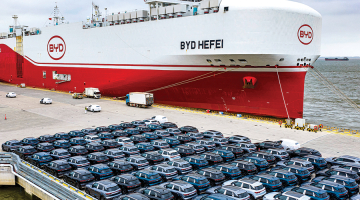 BYD elektroauto pirms iekraušanas kravas kuģī ostā pie Šanhajas.