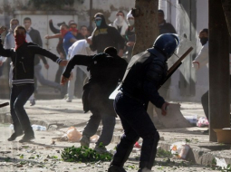 Protestētāji Alžīrā ar akmeņiem apmētā policistus. Foto: AFP/LETA