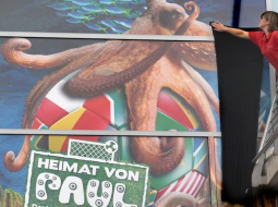 Akvārija darbiniece plakātam piestiprina melnu sēra lentu. Avots: AFP/LETA