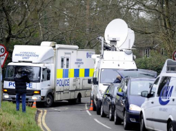 Britu policijas izmeklētāju busiņš un daudzo mediju automobiļi pie Borisa Berezovska mājas. Foto: EPA/LETA