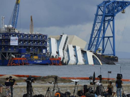 Žurnālisti jau svētdien ieņēmuši labākās vietas, lai fiksētu "Costa Concordia" izcelšanu. Foto: AFP/LETA