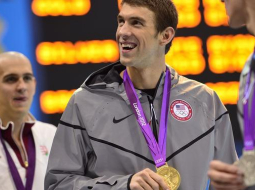 ASV peldētājs Maikls Feplss ar Londonā ceturtdien izcīnīto zelta medaļu 200 metru peldējumā. Foto: AFP/LETA