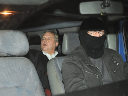 Dzintars Jaundžeikars kopā ar KNAB darbinieku tiek konvojēts uz apcietinājuma vietu. Foto: Lita Krone, LETA