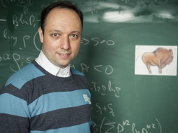 Reiz pie fizikas profesora Latvijas Universitātē ieradies kāds dziednieks. Sacījis, ka vēlas parunāt par "Higsa bizonu", ko pēta laboratorija CERN Šveicē - viņam šķiet, ka varot zinātniekiem šajā atklājumā palīdzēt. Vjačeslavs Kaščejevs (attēlā) uzaicinājis negaidīto ciemiņu uz kafiju, kādu stundu pārrunājuši, kas tad īsti ir Higsa bozons. Par godu šim amizantajam notikumam kolēģi vēlāk Vjačeslavam dzimšanas dienā uzdāvinājuši atklātnīti ar "Higsa bizonu". Foto: Emīls Desjatņikovs, F64