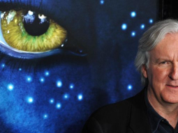 "Avatars" režisors Deivids Kamerons uz filmas plakāta fona. Avots: AFP/LETA