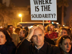 Ceturtdienas vakarā daudz ļaužu piedalījās demonstrācijā pie Kipras valdības ēkas. "Kur ir solidaritāte?" vaicā plakātā bēdu sagrautie kiprieši. Foto: AFP/LETA