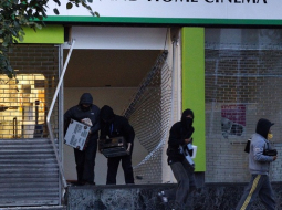 Laupītāji Birmingemā aplaupa elektropreču veikalu. Foto: AFP/LETA