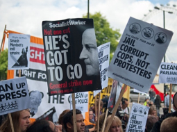 Protestētāji Londonā pauž attieksmi pret Mērdoka medijiem. Foto: AFP/LETA