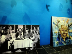 Izstādē Johannesburgā - glezna "Svētais vakarēdiens" (pa kreisi), ko radījis mākslinieks Dans Saimons, un "Mandela globālajā ikonā" - mākslinieks Daniels Mosako. Foto: AFP/LETA
