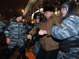 Miliči 15.decembrī aiztur cilvēkus pie Kijevas stacijas Maskavā, lai nepieļautu grautiņu izcelšanos. Foto: AFP/LETA