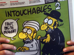 Uz žurnāla "Charlie Hebdo" jaunākā numura vāka trešdien redzama karikatūra, kurā ortodoksāls jūdaists invalīdu ratiņos stumj musulmaņu vīrieti. Foto: AFP/LETA
