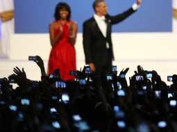 Mišela un Baraks Obama inaugurācijas ballē. Tūkstošiem roku ar mobilajiem telefoniem fotografē. Foto: AFP/LETA