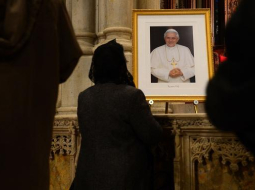 Lūdzēji baznīcā Ņujorkā pie Benedikta XVI fotogrāfijas. Foto: AFP/LETA