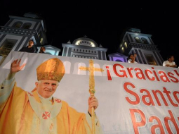 Ticīgie plakātā pateicas pāvestam Benediktam XVI. Foto: AFP/LETA