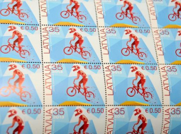 Jāņa Uzrauga veidotā pastmarka par godu BMX velosportam ir pirmā pastmarka ar nominālvērtību latos un eiro. Foto: Evija Trifanova, LETA