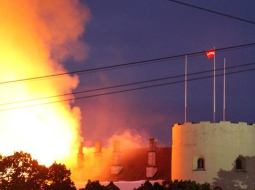 Degošā Rīgas pils. Tornī joprojām it simboliski plīvo valsts karogs. Foto: Egons Ansbergs, F64
