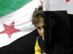 Bērns pie Sīrijas valsts karoga. Foto: AFP/LETA