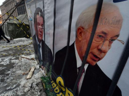Bijušie - Ukrainas valdības vadītāja Mikolas Azarova (pa labi) un eksprezidenta Viktora Janukoviča portreti Maidana laikā šogad. Foto: AFP/LETA