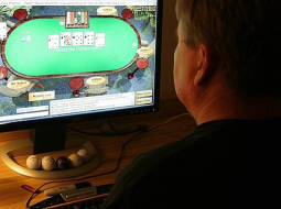 Vīrietis spēlē pokeru ar savu datoru. Foto: AFP/LETA