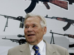 Mihails Kalašņikovs fotografēts 2007.gadā. Aiz viņa redzams leģendārais ierocis. Foto: AFP/LETA