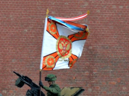 Krievijas armijas karavīrs uz bruņutransportiera nostiprina Svētā Georga karogu, gatavojoties 9.maija parādei Maskavas Sarkanajā laukumā. Foto: AFP/LETA
