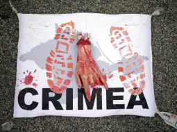 Protestētāju plakāts Vīnē 24.jūnijā, paužot prezidentam Putinam, kurš Vīnē ieradies oficiālā vizītē, nostāju pret Krievijas aneksiju Krimā. Foto: EPA/LETA