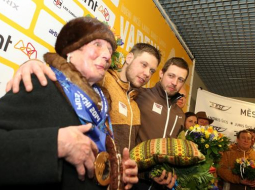 Vecmāmiņa Lilija Šica ar mazdēliem Soču olimpisko spēļu bronzas medaļu ieguvējiem - kamaniņu braucējiem Juri un Andri Šiciem svinīgās sagaidīšanas ceremonijas laikā lidostā "Rīga". Foto: Edijs Pālens, LETA