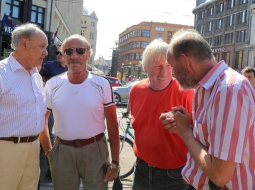 Partijas "Par cilvēka tiesībām vienotā Latvijā" pārstāvis Vladimirs Buzajevs (pirmais no labās) un Jakovs PLiners (otrais no kreisās) kopā ar domubiedriem pirmdien pie "Laimas" pulksteņa, vācot ziedojumus Austrumukrainas separātistu atbalstam. Foto: Evija Trifanova, LETA