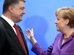 Vācijas kanclere Angela Merkele sveic Ukrainas prezidentu Petro Porošenko ar asociācijas līguma parakstīšanu. Foto: AFP/LETA