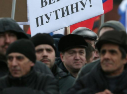 Tauta Maskavas Sarkanā laukumā, "svinot" Krimas aneksiju. Plakāts vēsta: "Ticam Putinam!" Foto: EPA/LETA
