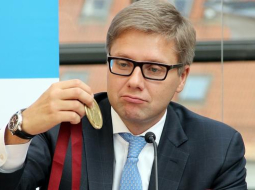 Rīgas mērs Nils Ušakovs pēta 'Nordea maratona' medaļu. Foto: Sintija Zandersone, LETA